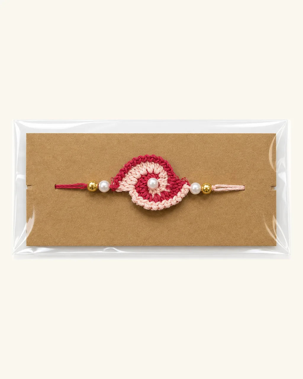 Pink and Beige Swirl Crochet Rakhi in its gift sleeve