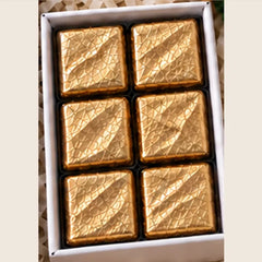 Six assorted gold foil chocolates in a 4 inch box